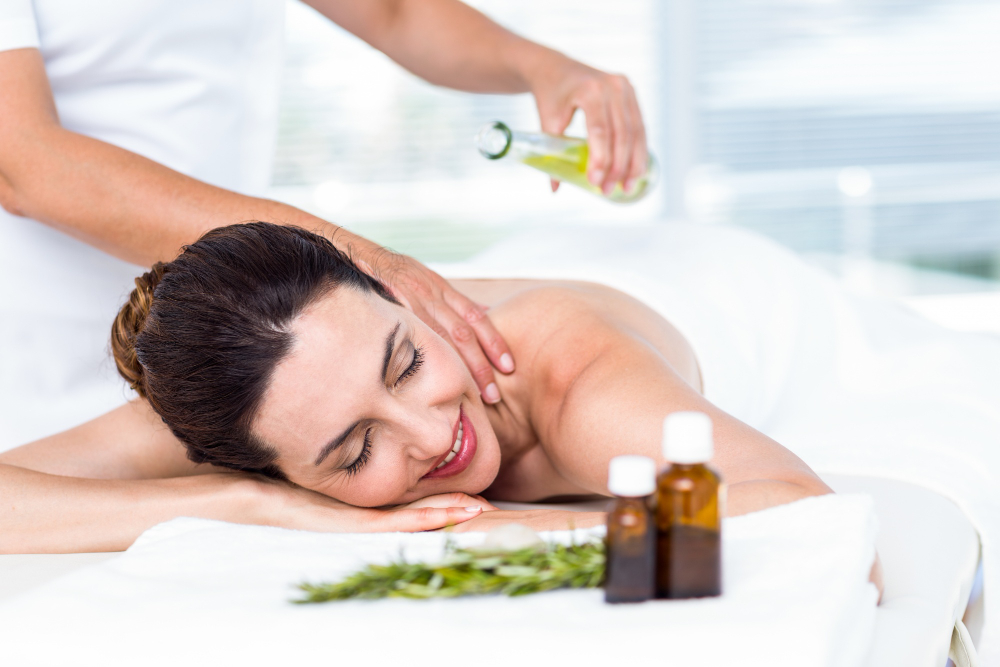 Smiling woman getting an aromatherapy treatment - benefits of aromatherapy massage
